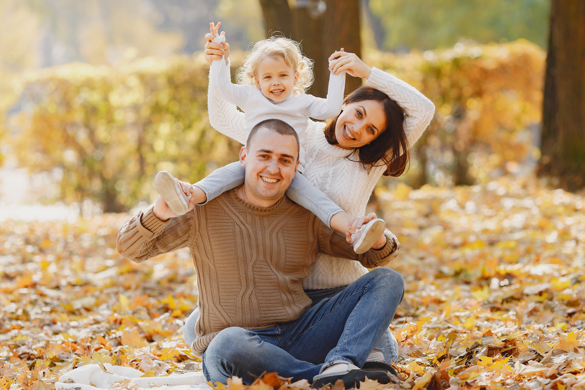 Cheerful family having fun in autumn park